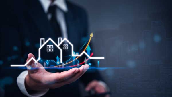 vecteezy_businessman-holding-house-and-house-symbol-on-city-background_600w